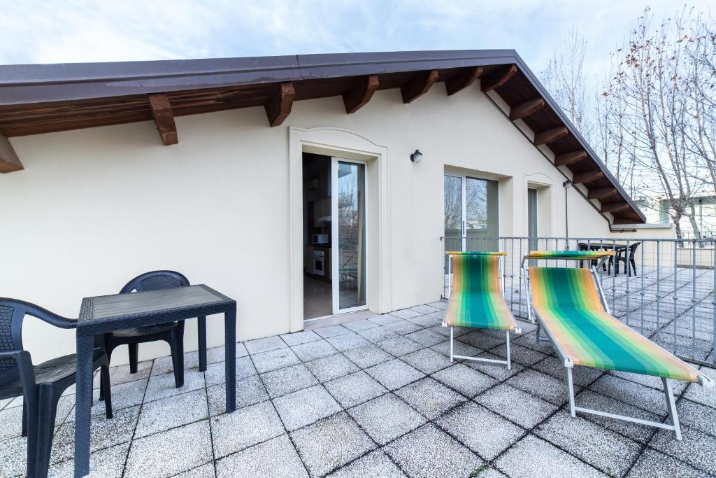 une terrasse avec une table et des chaises ainsi qu'une maison dans l'établissement Residenza Melucci, à Rimini