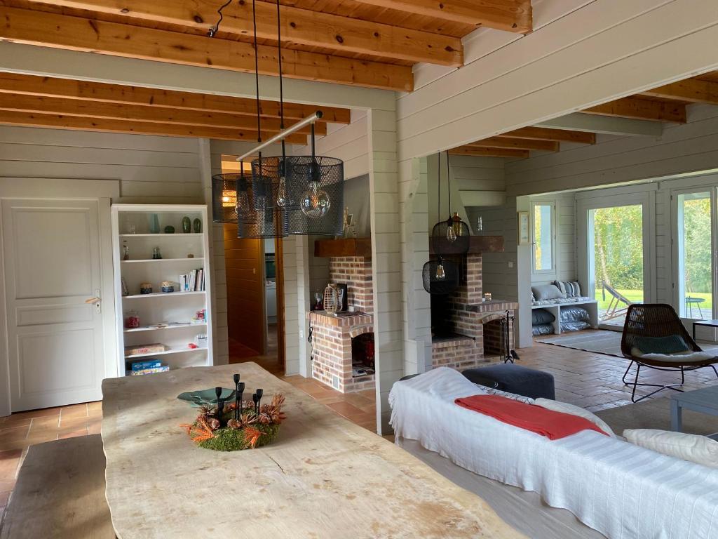 un salon avec un canapé et une cheminée dans l'établissement Gîte des Etangs, à Glanville