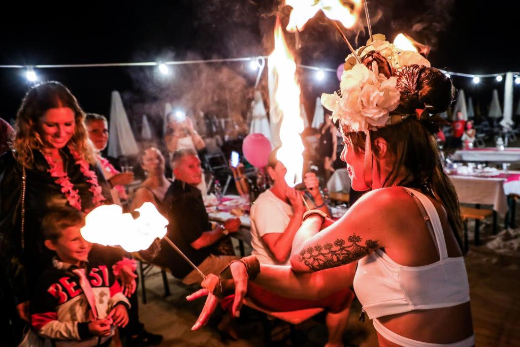 un groupe de personnes assises autour d'une table avec des feux dans l'établissement Hotel Rosalba - Valentini Family Village, à Bellaria-Igea Marina 47 autres photos