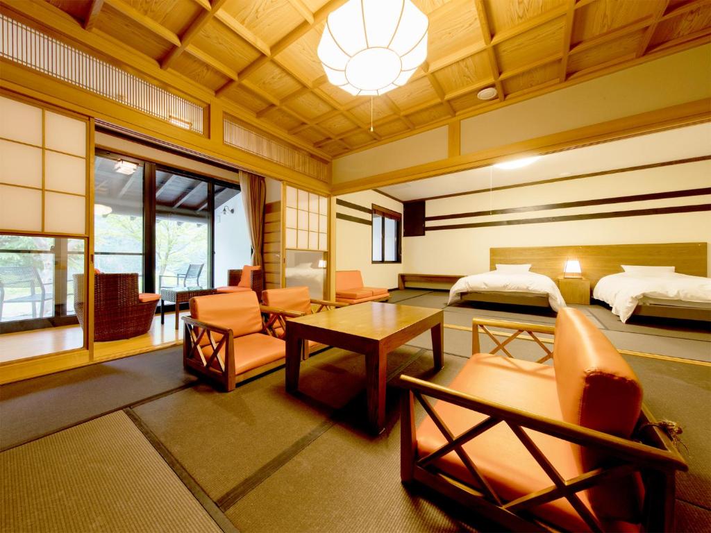 Cette chambre comprend une chambre, un lit et une table. dans l'établissement Kinshuusanso, à Kawaba 37 autres photos