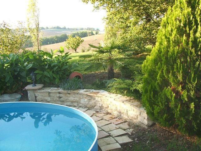une grande baignoire bleue installée dans un jardin dans l'établissement Gite de La Cheneraie, à Montpezat-de-Quercy
