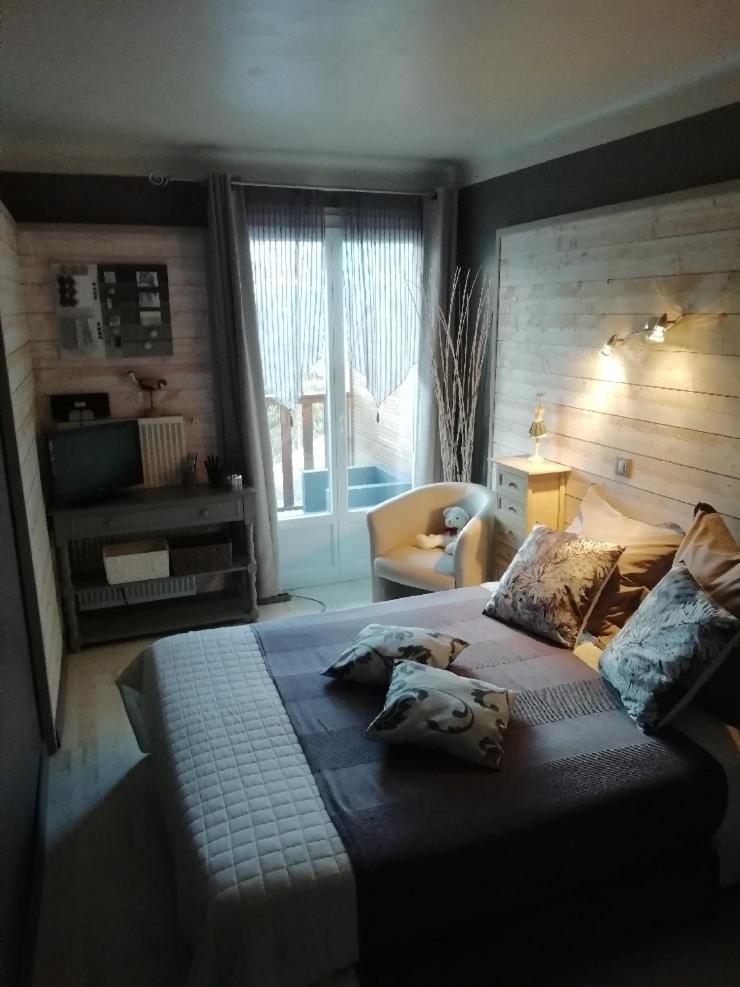 une chambre avec un lit, une chaise et une fenêtre dans l'établissement Hotel & Restaurant Le Chalvet, à Embrun