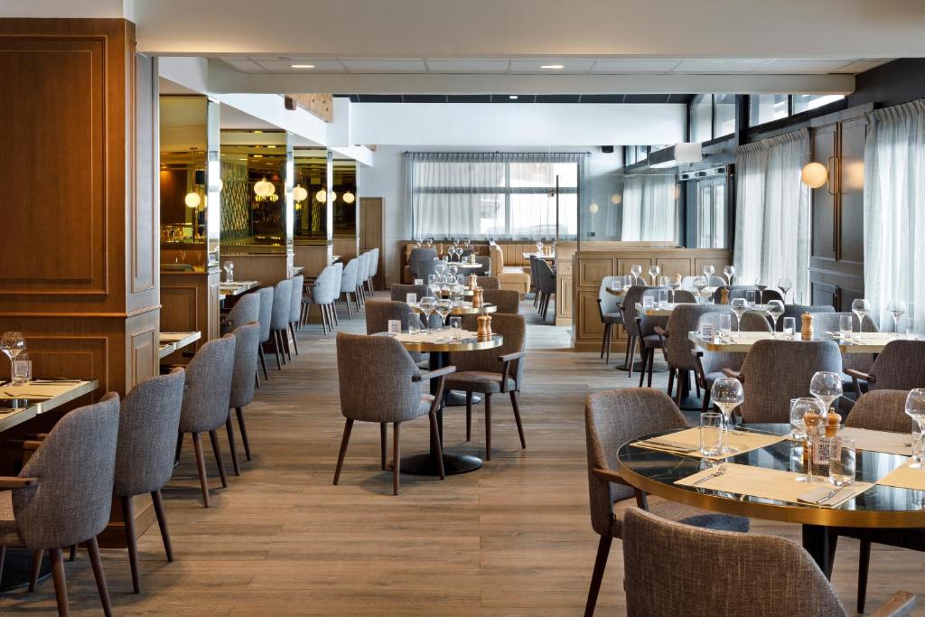 une salle à manger avec des tables et des chaises dans un restaurant dans l'établissement Hôtel Marielle, à Val Thorens