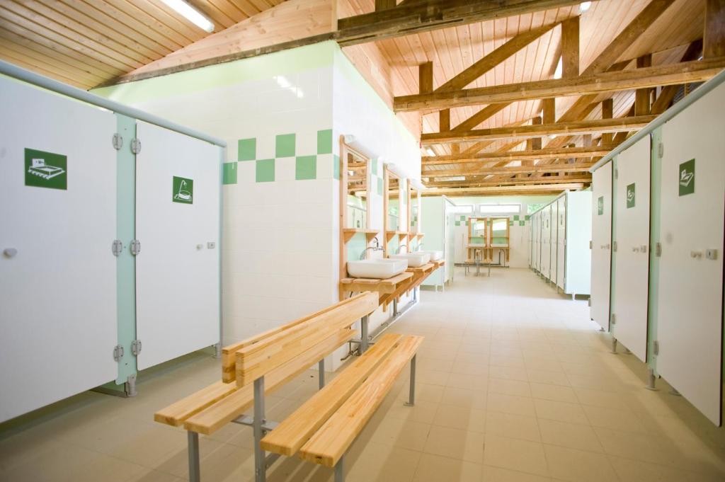 un couloir avec des bancs et des casiers dans une salle de sport dans l'établissement Camping le Nid du Parc, à Villars-les-Dombes