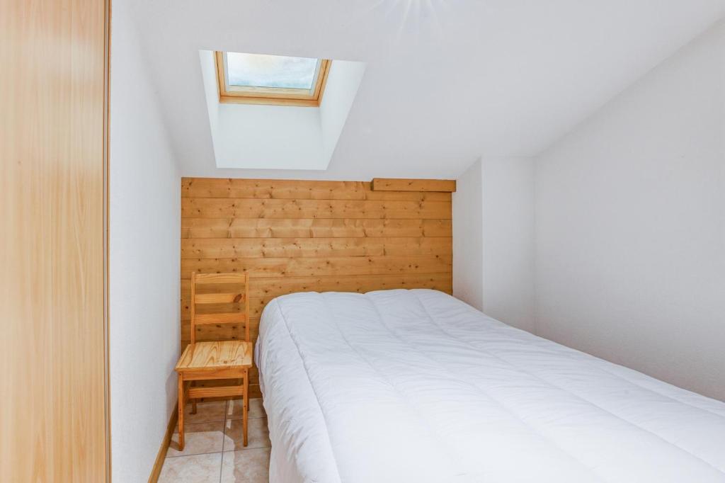 une petite chambre avec un lit et une fenêtre dans l'établissement Schuss 2 - Appartement 2 chambres - Val d'Arly, à Flumet