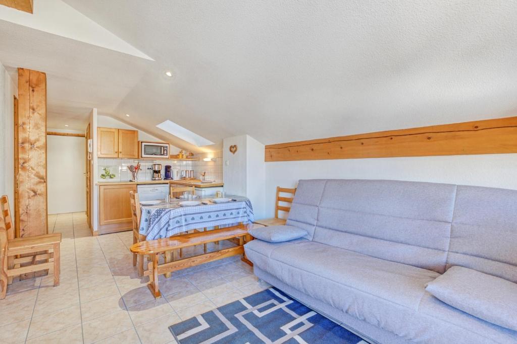 un salon avec un canapé et une table dans l'établissement Schuss 2 - Appartement 2 chambres - Val d'Arly, à Flumet