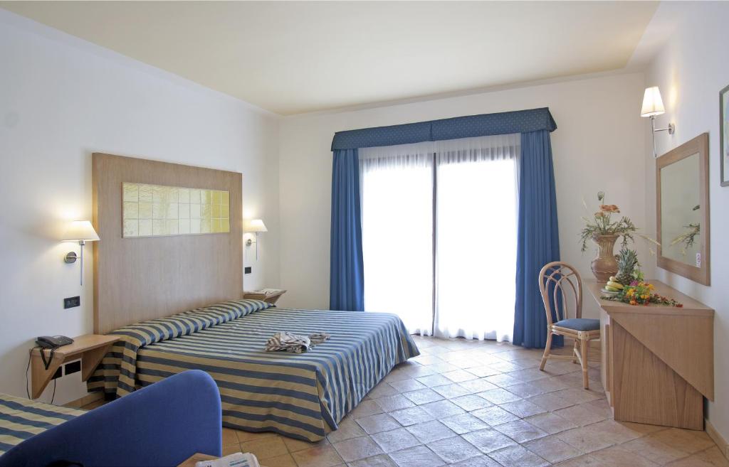 une chambre d'hôtel avec un lit et une fenêtre dans l'établissement TH Le Castella - Baia degli Dei Village, à Le Castella
