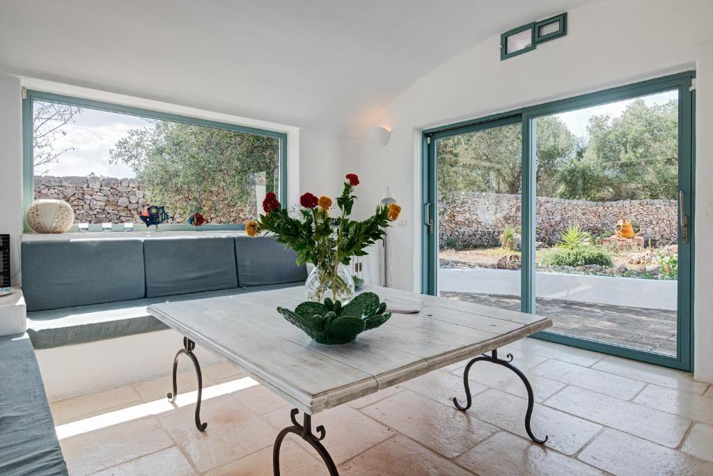 un salon avec une table avec des fleurs dessus dans l'établissement Trullo Paola, à Ceglie Messapica 38 autres photos