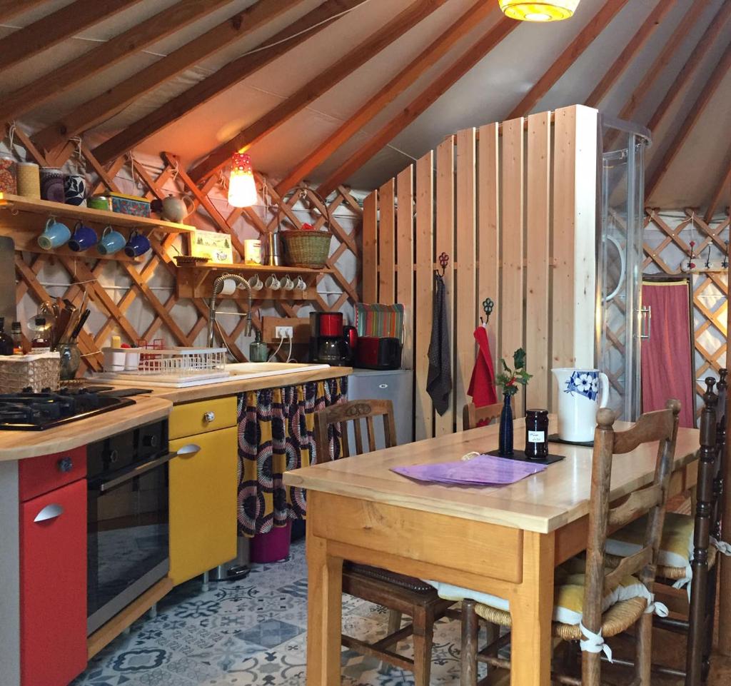 - une cuisine avec une table en bois et une cuisinière dans l'établissement La Yourte, à Moussages