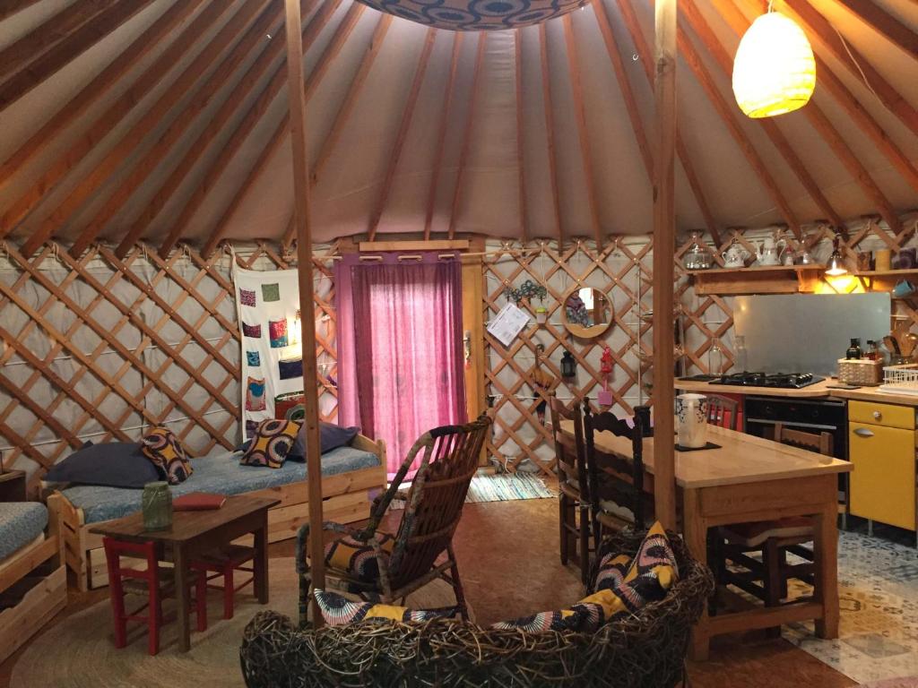Cette chambre comprend une yourte avec une table et des chaises. dans l'établissement La Yourte, à Moussages