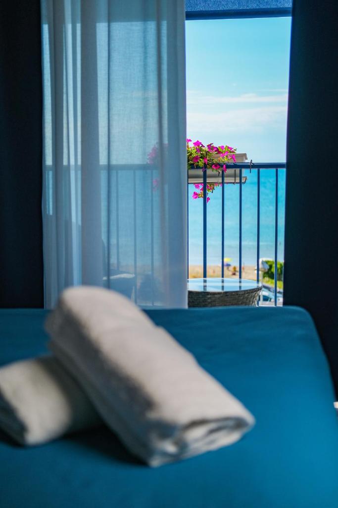 un oreiller sur un lit avec vue sur l'océan dans l'établissement Ticho's Greenblu Hotel, à Castellaneta Marina