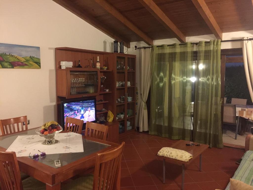 un salon avec une table et une télévision dans l'établissement Villa Holiday Park Stintino - Piscina privata ed esclusiva, à Stintino