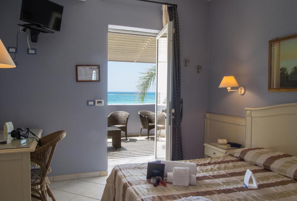 une chambre avec un lit et une vue sur l'océan dans l'établissement Conchiglia Azzurra Resort & Beach, à Porto Cesareo