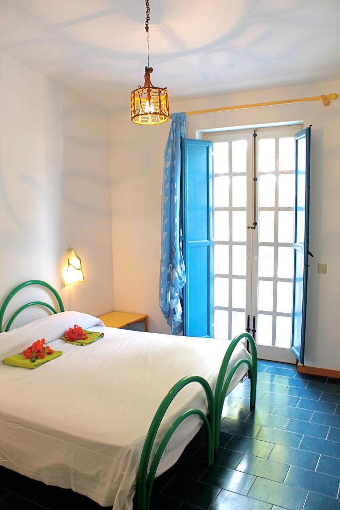 une chambre avec un grand lit blanc et une fenêtre dans l'établissement Villa Teti - Sicilia, à Campofelice di Roccella