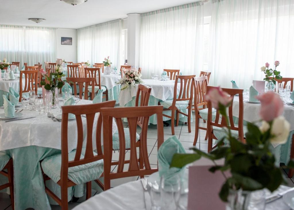 une salle de banquet avec des tables et des chaises avec des fleurs dans l'établissement Hotel Maria, à Castellabate