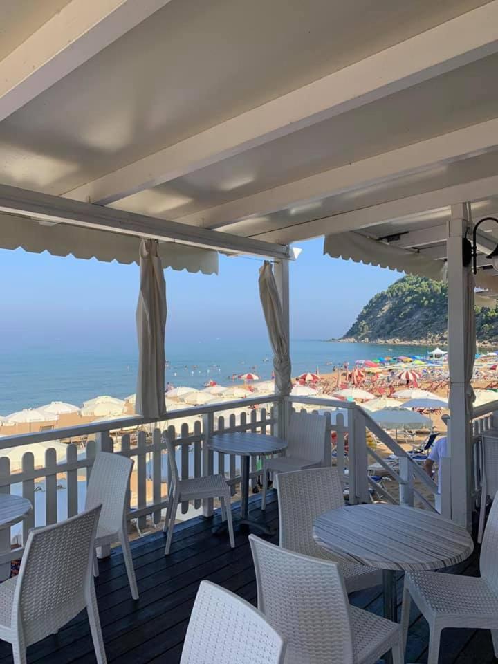 - un balcon avec des tables et des chaises et la plage dans l'établissement Hotel Maria, à Castellabate
