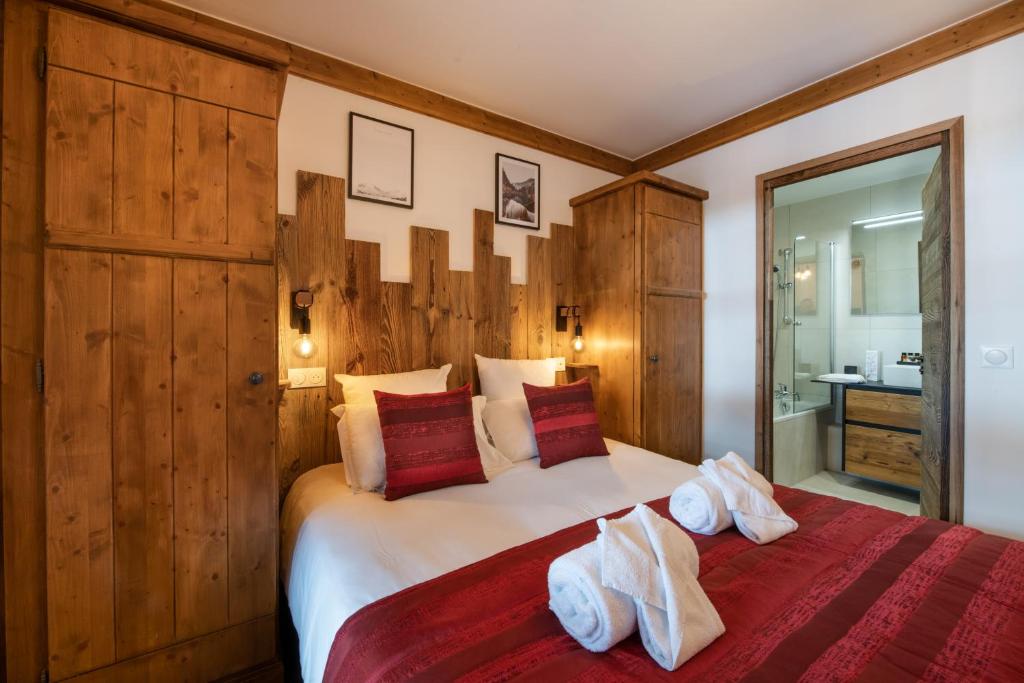 une chambre avec un grand lit blanc et des murs en bois dans l'établissement Superbe appart Arc 1950 4/6pers dans résidence hôtelière 5* - Skis aux pieds, à Arc 1950