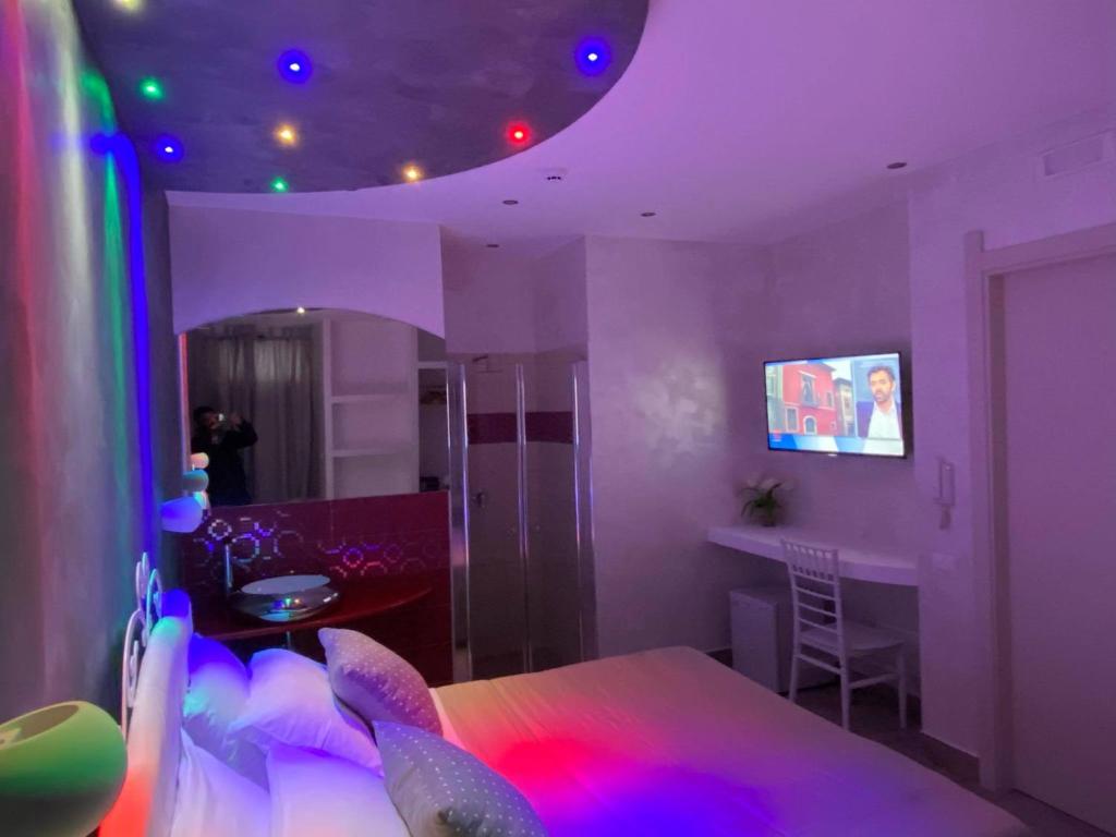 Cette chambre violette comprend un lit et une salle à manger. dans l'établissement La Porta del Mare, à Tropea