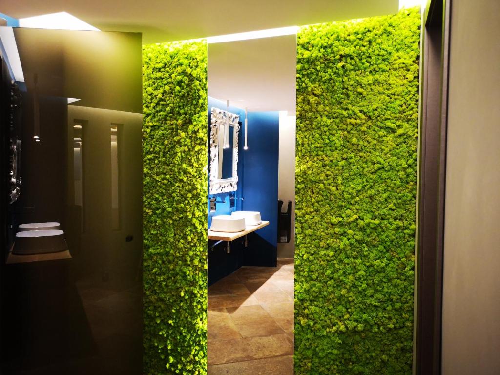 - une salle de bains avec un mur vert à côté d'un lavabo dans l'établissement Club Esse Roccaruja, à Stintino