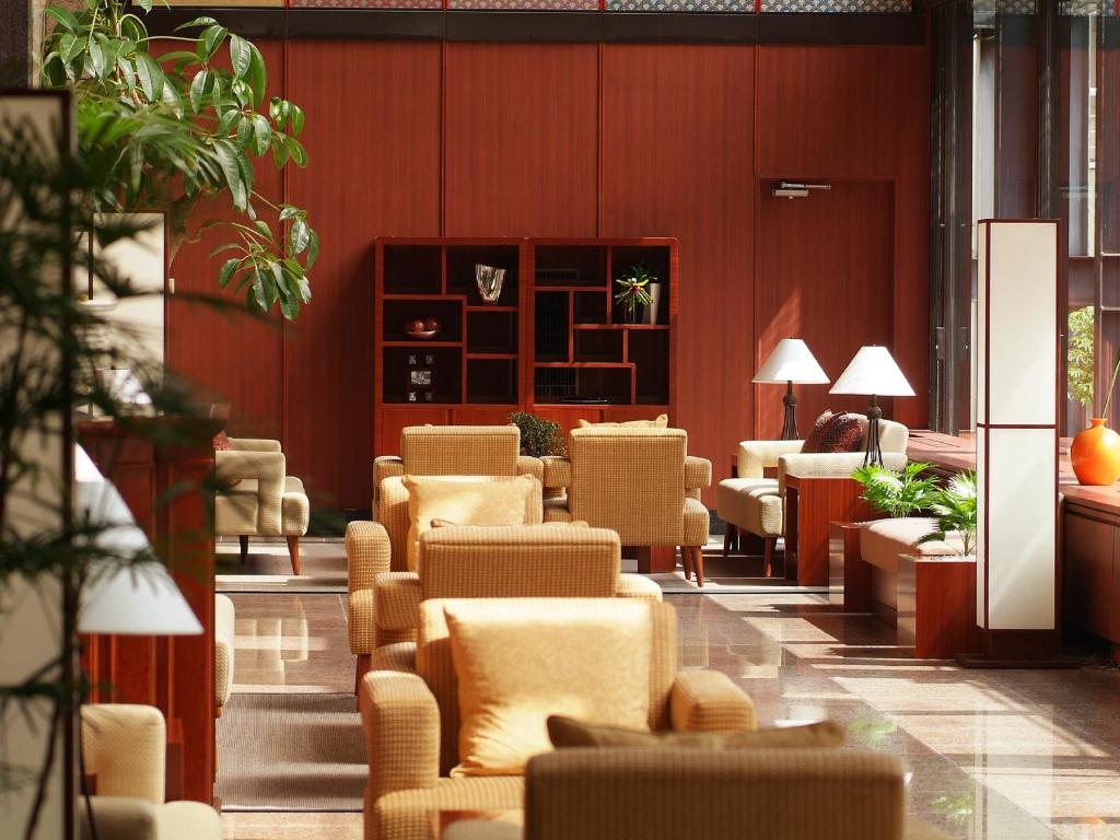 un coin salon avec des chaises et des tables dans un bâtiment dans l'établissement Kinugawa Plaza Hotel, à Nikkō