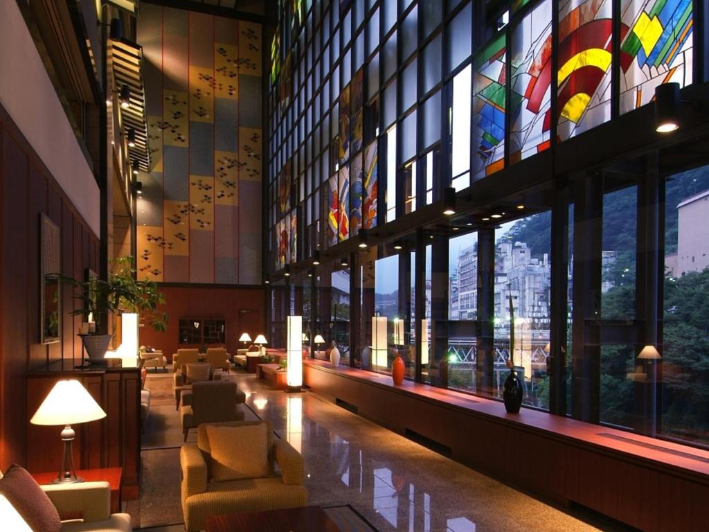 un hall d'un immeuble avec de nombreuses fenêtres dans l'établissement Kinugawa Plaza Hotel, à Nikkō