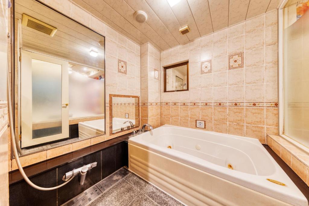 une salle de bain avec une baignoire, un lavabo et un miroir dans l'établissement Hotel Atlantis Hawaiian Resorts(Adult only), à Saitama