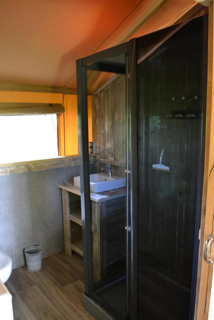 une salle de bain avec douche et lavabo dans l'établissement Les lodges du Moulin, à Saint-Laurent 19 autres photos