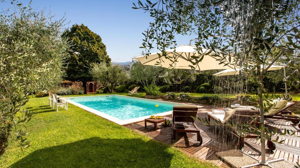 une cour avec une piscine et un parasol dans l'établissement VILLA IL COLLE DI MORIANO 8, Emma Villas, à Lucques