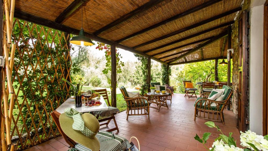 d'une terrasse avec des chaises, des tables et une clôture. dans l'établissement VILLA IL COLLE DI MORIANO 8, Emma Villas, à Lucques
