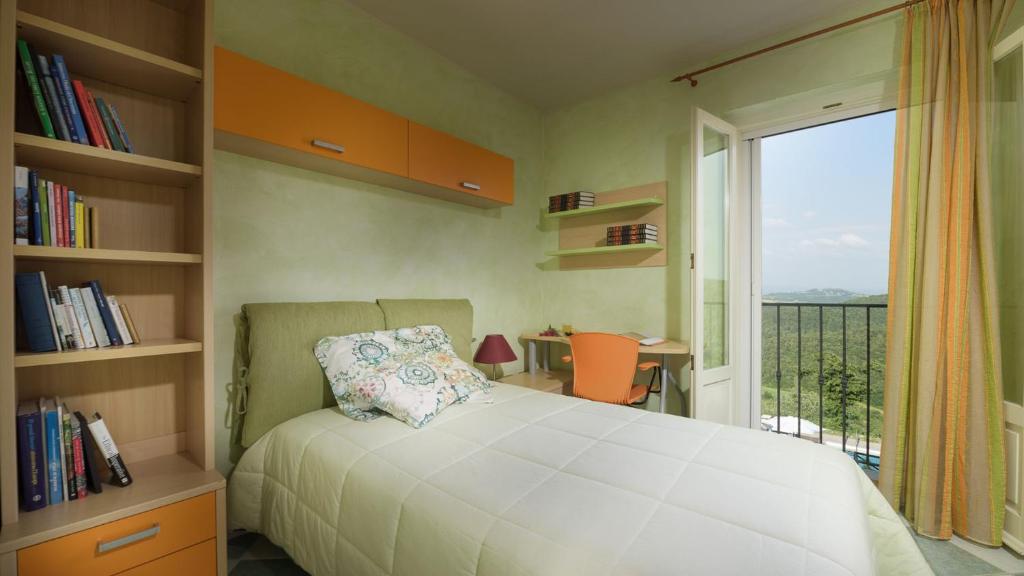une chambre avec un lit et une fenêtre avec un balcon dans l'établissement VILLA VITTORIA D'ANGHIARI 7&3, Emma Villas, à Anghiari