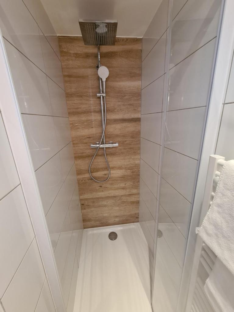 une douche avec pommeau de douche dans une salle de bain dans l'établissement Chalet Le Granitic, aux Menuires 29 autres photos