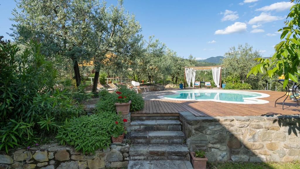 une piscine dans un jardin avec un mur en pierre dans l'établissement BUCA DELLE FATE 8, Emma Villas, à Case Malva