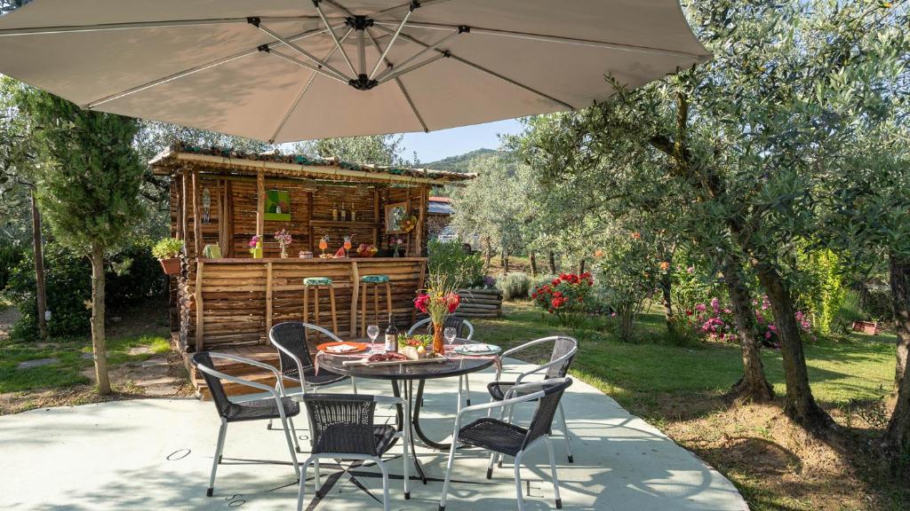 - une table et des chaises sous un parasol sur la terrasse dans l'établissement BUCA DELLE FATE 8, Emma Villas, à Case Malva