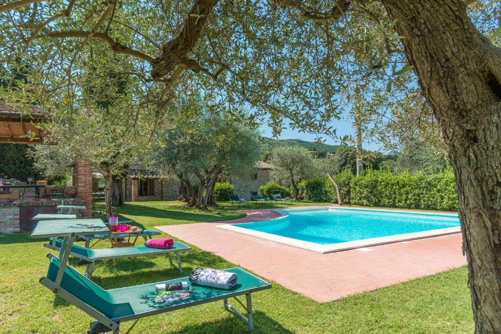 une arrière-cour avec une piscine, une table et un arbre dans l'établissement Casa Torrione 14, Emma Villas, à Paciano