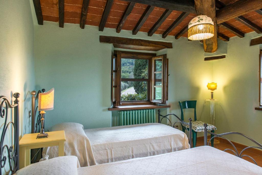 une chambre avec deux lits et une fenêtre dans l'établissement Casa Torrione 14, Emma Villas, à Paciano