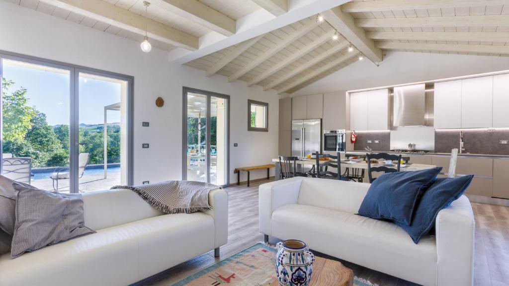un salon avec deux canapés blancs et une cuisine dans l'établissement Villa Mia 6, Emma Villas, à Mercato Saraceno