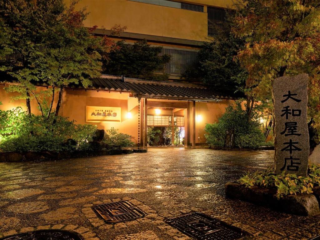 un bâtiment avec une enseigne au milieu d'une rue dans l'établissement Yamatoya Honten, à Matsuyama