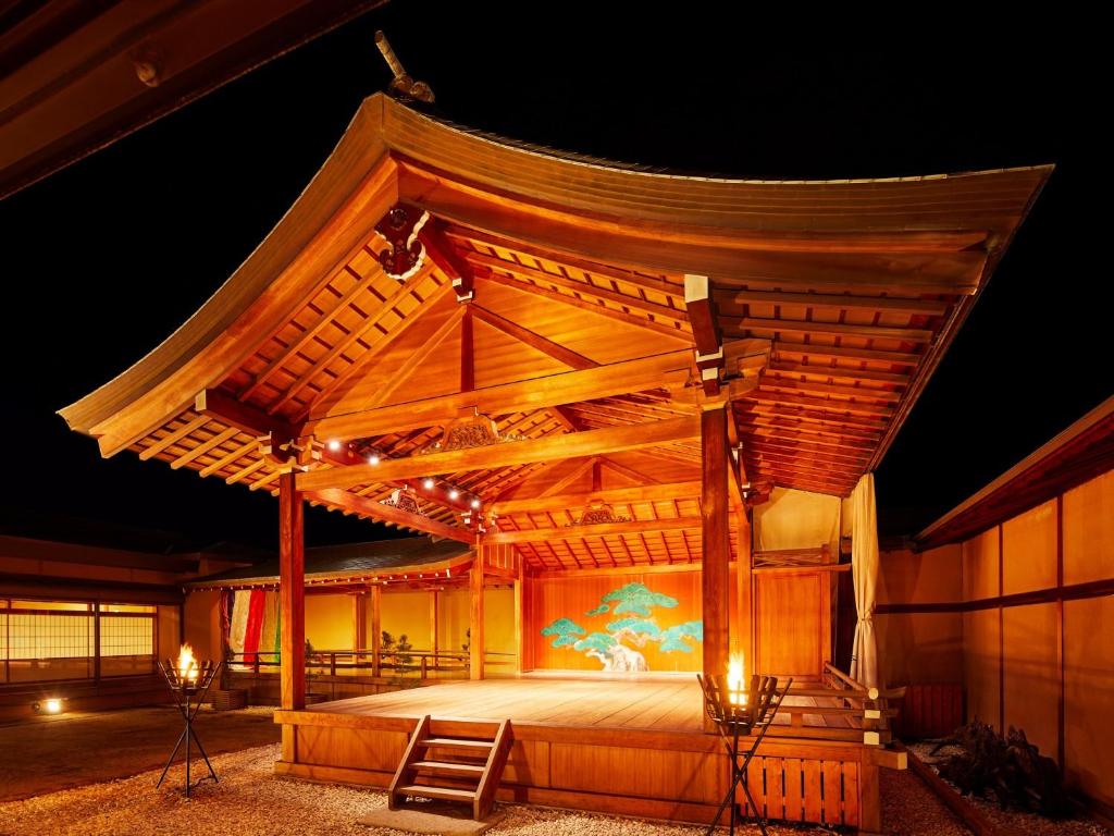 une grande scène en bois éclairée la nuit dans l'établissement Yamatoya Honten, à Matsuyama
