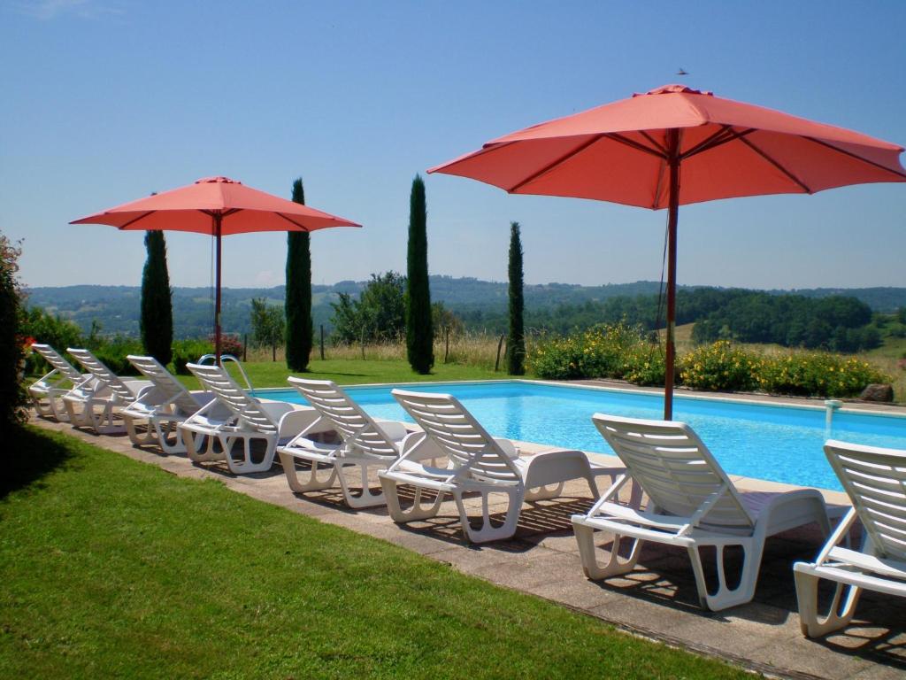 une rangée de chaises et de parasols à côté d'une piscine dans l'établissement Domaine Leyvinie, gite Mourvedre, close to the Dordogne, à Perpezac-le-Blanc