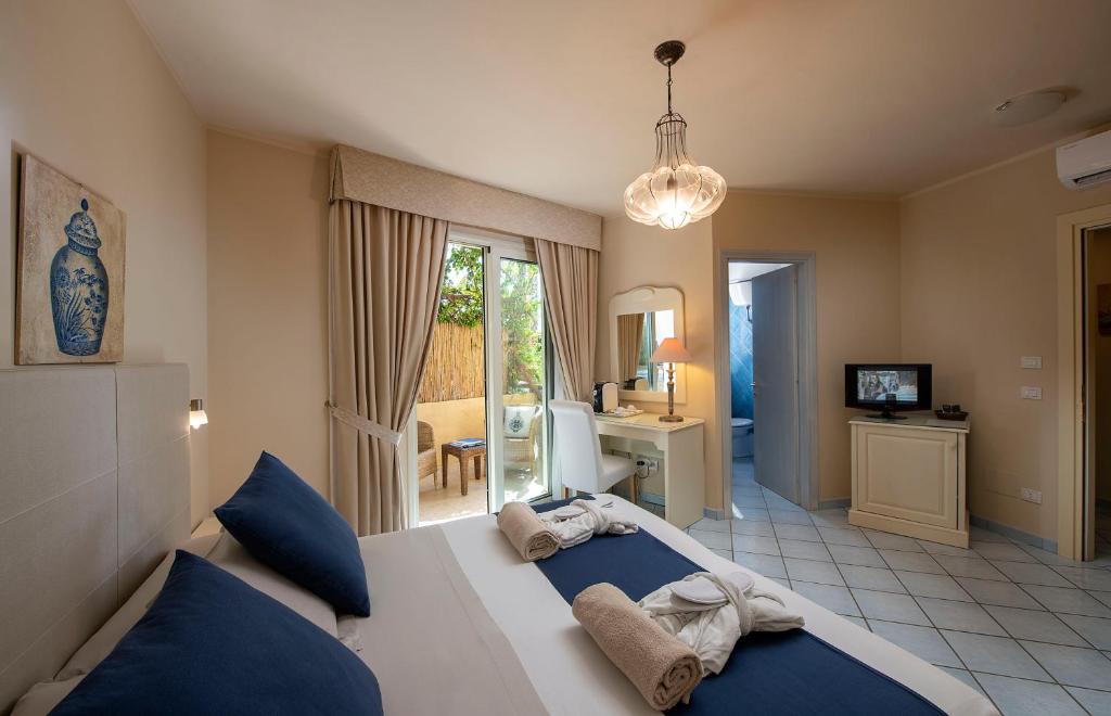 une chambre avec un grand lit avec des oreillers bleus dans l'établissement Boutique Hotel Su Sergenti, à Villasimius 44 autres photos