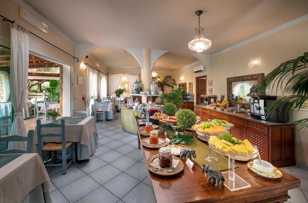 une salle à manger avec une table avec des bananes dessus dans l'établissement Boutique Hotel Su Sergenti, à Villasimius