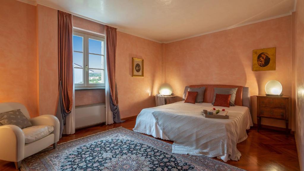 une chambre avec un lit, une chaise et une fenêtre dans l'établissement VILLA GABRI 8&2, Emma Villas, à Montecarlo