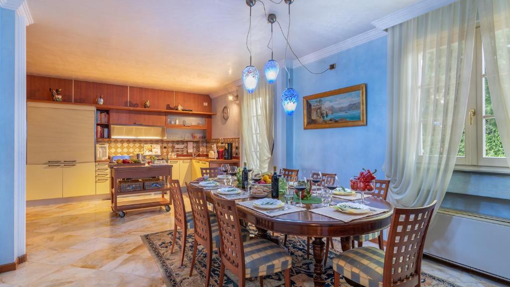 une salle à manger avec une table et des chaises ainsi qu'une cuisine dans l'établissement VILLA GABRI 8&2, Emma Villas, à Montecarlo