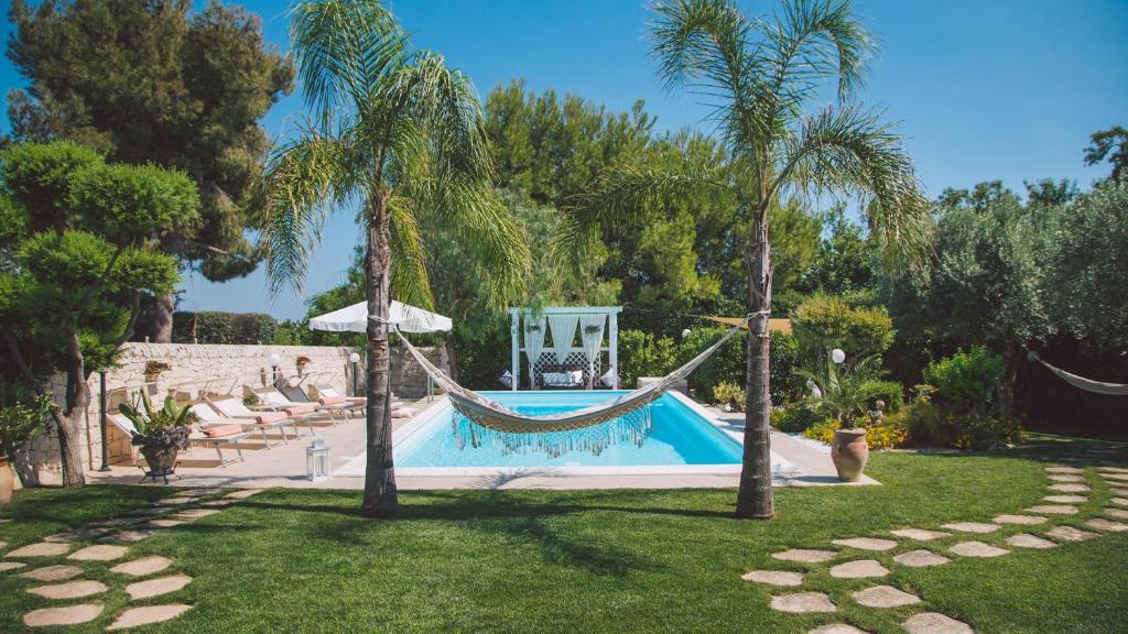 - une piscine avec hamac dans une cour agrémentée de palmiers dans l'établissement VILLA FERRADINA 4&2, Emma Villas, à Ispica