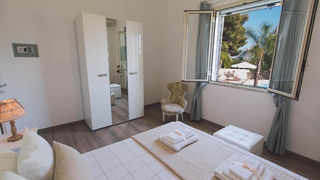 - un salon avec une grande fenêtre et une chaise dans l'établissement VILLA FERRADINA 4&2, Emma Villas, à Ispica