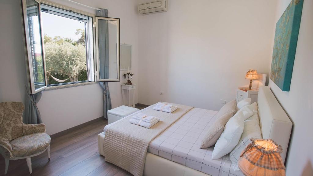 une chambre avec un lit, une fenêtre et une chaise dans l'établissement VILLA FERRADINA 4&2, Emma Villas, à Ispica 25 autres photos