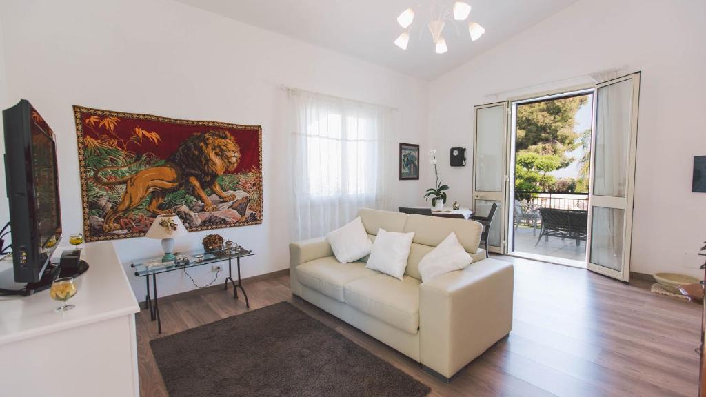 un salon avec un canapé blanc et un tableau dans l'établissement VILLA FERRADINA 4&2, Emma Villas, à Ispica