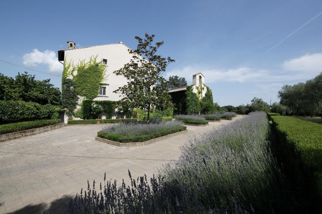une maison blanche avec un jardin en face dans l'établissement Commenda Cavalieri Ordine di Malta, à Vignanello