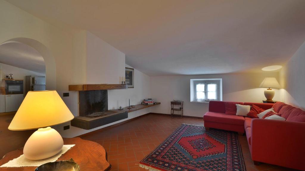un salon avec un canapé rouge et une cheminée dans l'établissement Villa Alida 12, Emma Villas, à Capannori
