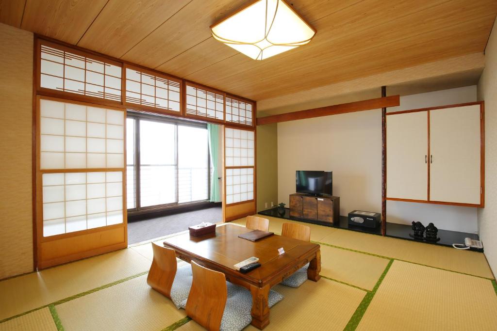 une pièce avec une table et des chaises dans une pièce dans l'établissement Toya-onsen Hotel Hanabi, à Lac Tōya